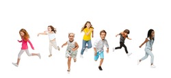 Running. Group of kids or pupils, girls and boys in colorful casual clothes isolated over white studio background. Creative collage. Back to school, education, childhood concept. Cheerful girls.