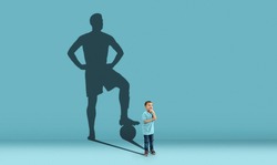 Childhood and dream about big and famous future. Conceptual image with boy and shadow of sportive male football player, champion on blue background. Childhood, dreams, imagination, education concept.