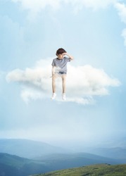 Looking down. Creative collage with little preschool boy sitting on white cloud and flying at sky. Concept of childhood, happiness, dreams, travels, adventure, ad. See the world by children's eyes