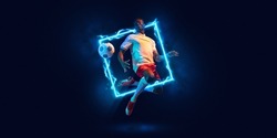 Fluorescence. Young man, professional football player in motion and action with ball isolated on dark background with neoned geometric figure. Concept of active lifestyle, health, sport, motivation