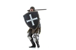 Portrait of brutal serious man, medieval warrior or knight in protective covering with sword preparing to attack isolated over white studio background. Comparison of eras, history, renaissance style