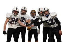 Players. Group of young sportive men, professional american football players in sports uniform and equipment posing isolated on white background. Concept of sport, competition, achievements, action