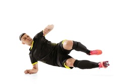 Back tackle. Professional male football soccer player doing sliding tackle isolated on white studio background. Concept of sport, goals, competition, hobby, ad. Sportsmen wearing black football kit