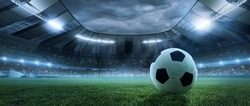 After game. Closeup soccer ball on grass of football field at crowded stadium with spotlights at evening time. Concept of sport, art, energy, power. Poster for ad, design