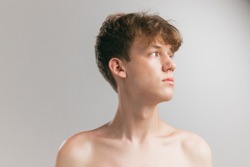 Neck and shoulders. Closeup young man, teen isolated on grey studio background. Concept of teenage skin care, health, cosmetics for problem skin, youth. Art, fashion, healthy lifestyle and ad