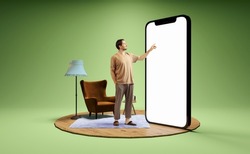 Pointing at device screen. Photo and 3d illustration of man standing next to huge 3d model of smartphone with empty white screen isolated on green background. Mockup for ad, text, design, logo