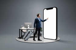 Booking business trip online. Young man, businessman standing in front of 3d model of cellphone with blank white screen isolated on grey background. On-line shopping, trip, travel, ad, sales,