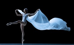 Graceful classic ballerina dancing with weightless cloth isolated on black studio background. Theater, art, beauty, grace, action and motion, ad concept. Artist of ballet in solo performance