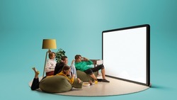Astonished young people, emotional friends watching football match, sport show. Youth sitting on sofa in front of huge 3D model of tv screen. Concept of sport, leisure activities, betting, ad