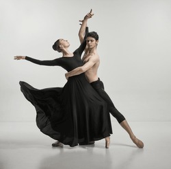 Young man and woman, ballet dancers performing isolated over grey studio background Tenderness and passion. Concept of classical dance aesthetics, choreography, art, beauty. Copy space for ad
