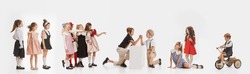 Collage. Playful little boys and girls, kids, children in stylish retro clothes playing isolated over white background. Communication. Concept of childhood, lifestyle, fun, education, game