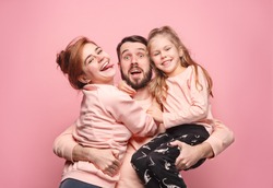 Happy young family with one little daughter posing together