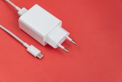 Charger and USB cable type C over red background