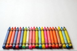 Multicolored crayons lined up on white background. Group of crayons of different colors.