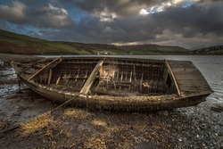 Abandoned old rowing boat at side of loch