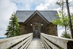 Wooden boardwalk leading to rustic wooden and brick cabin entrance in Snowshoe, West Virginia