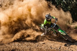 Motocross rider creates a huge cloud of dust and debris