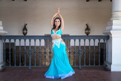 beautiful young belly dancer is posing for the camera in a photo shoot. The woman is beautiful and dressed in traditional clothes. Beauty, folklore and belly dance concept.