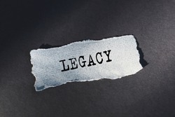 Legacy text, inscription, phrase is written on a torn paper that lies on a dark table. Business concept.