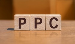 PPC text on wooden cubes on orange background, business concept. PPC short for Pay Per Click