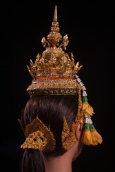 wearing a traditional and original Thai retro dress with a beautiful headdress costumes which has a golden color, is used to wear the dancer's head.