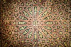 Beautiful ceiling with geometric design. Abstract wooden lines with yellow and green details. Seamless background in old arabic style. Traditional islamic art. Indoor medieval house decoration.