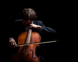 musician playing the cello. Black background