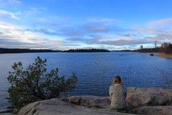 Beautiful view over a Swedish landscape. Part of the lake Malar or Mälaren. Camouflaged woman blending in. Autumn or fall time. During November in Hässelby, Stockholm, Sweden, Scandinavia, Europe.