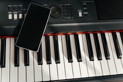 Smartphone on musical synthesizer keyboard. Smartphone on electronic piano.
