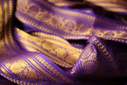 Purple violet Indian Sari border with gold paisley pattern. purple background.