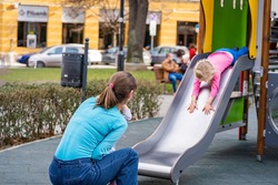 Mother plays with little girl on a playground in Sofia, Bulgaria