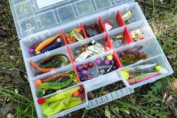 A box of baits for catching fish. Multi-colored lures of different shapes. High quality photo