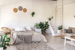 
Luxury bedroom design in a rustic cottage in a minimalist style. white walls, panoramic windows, wooden elements of decoration on the ceiling, rope swings in the middle of a spacious room.