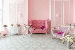 royal sitting room luxury interior of large flat in pink colors with expensive furniture in rich barocco style decorated with flowers in vases.  royal sitting room