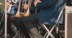 Brass band plays jazz music at a concert. Daylight, there is a score with sheet music. The concept of live, musical performance and virtuosity of playing a wind musical instrument