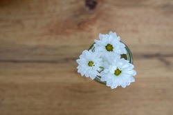 marguerite (leucanthemum vulgare), White flowers bouquet. White flowers on the brown wooden background. Flowers with green leaves. Postard. Space for copy. Space for text. Flowers in a vase. 