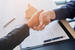 Real estate broker agent Shake hands after customer signing contract document for ownership realty purchase in the office, Business concept and  signing contract