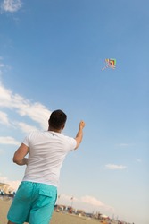 A man holds a kite by a rope. Image with selective focus.