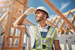 Pleased bearded man touching helmet while working at his project, wearing special uniform