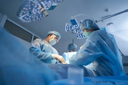 Surgical team making operation in sterile medical room