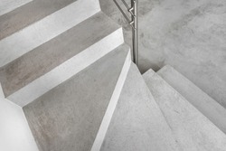 Grey microcement stairs. Stairs viewed from above. Modern design and innovative material. Metal railing.