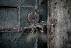 An old lock between dust and cobwebs.