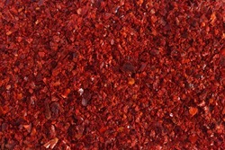 Heap of dried red chili flakes as background. Spices and herbs. Top view. Free space for text.