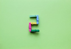 Number 2 made of clothespin in color on a green background