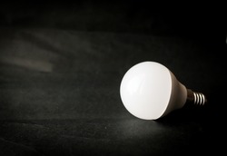 LED bulb on a dark background. Place for you text.