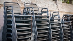 Metallic cafe chairs pile in the street