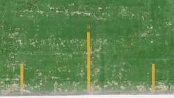 Yellow lines in green chipping paint wall fronton background