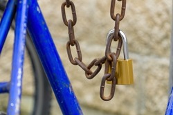 Closed padlock on a rusty chain. Locked chain. The bike is parked with a chain.