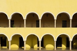 Facade of a colonial building in the center of Valladolid, Mexico. Minimalistic empty building with arches and columns. The concept of minimalism in architecture.