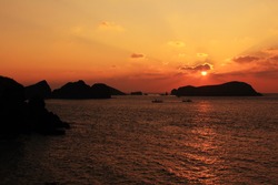A sunset scene with the silhouette of islands and clouds on Jeju Island